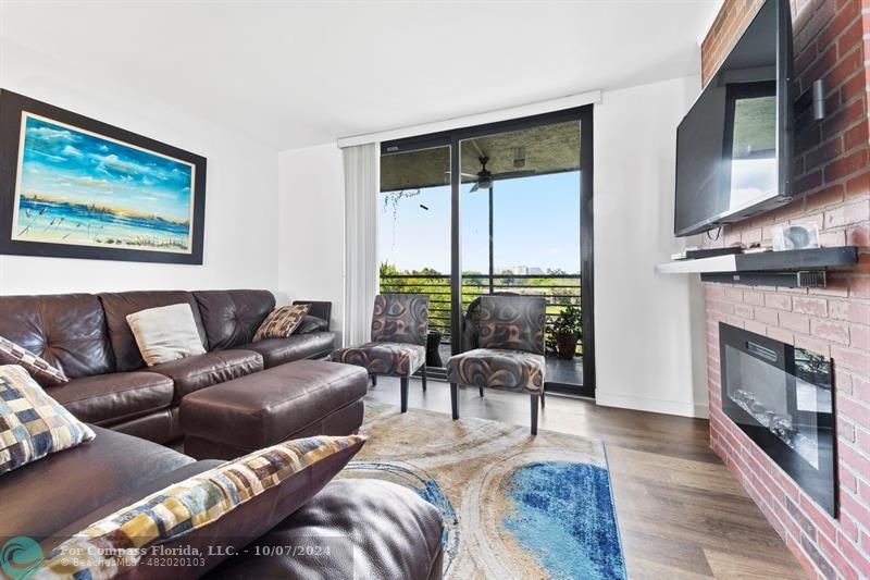 a living room with furniture large window and fireplace