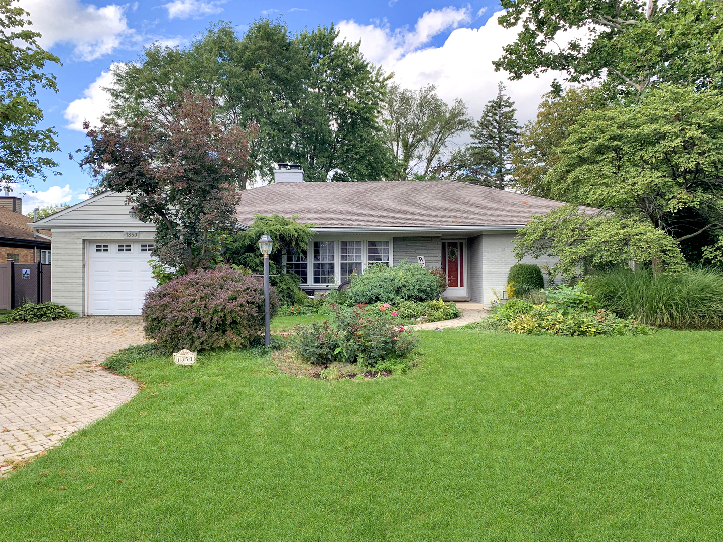 a front view of a house with a garden and yard