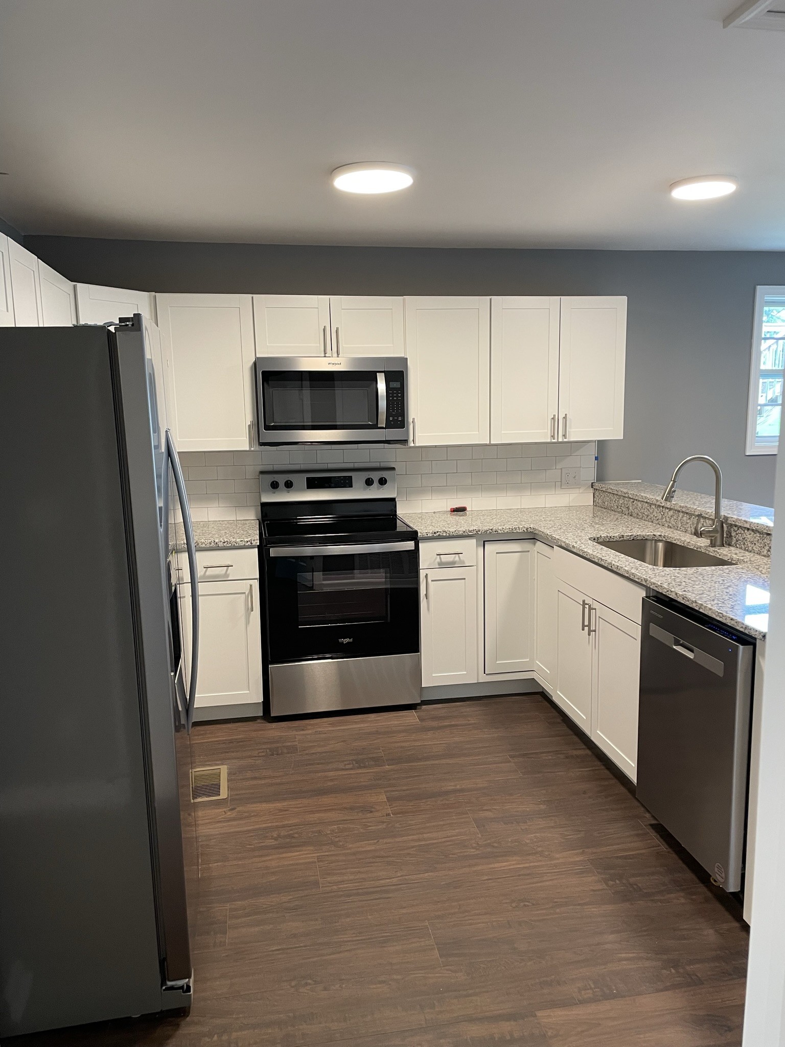 a kitchen with stainless steel appliances a refrigerator sink and microwave