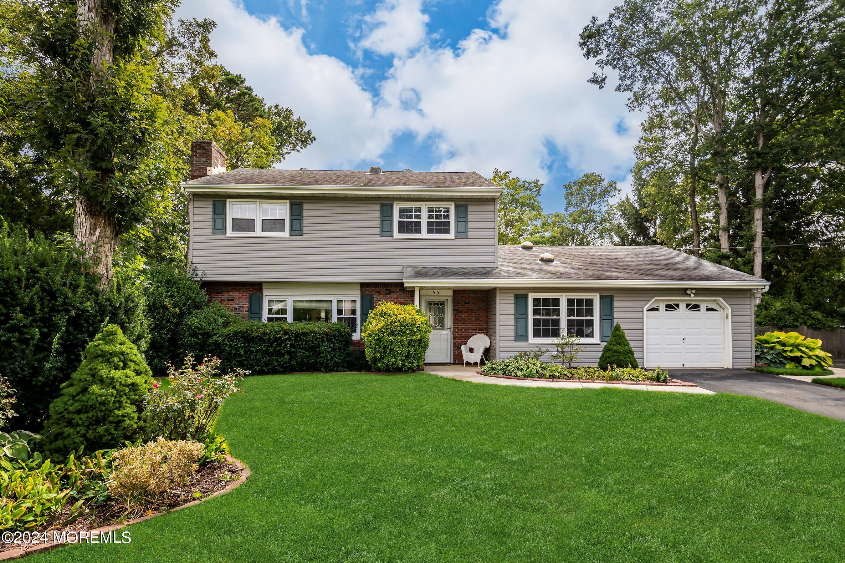 a front view of a house with a garden and plants