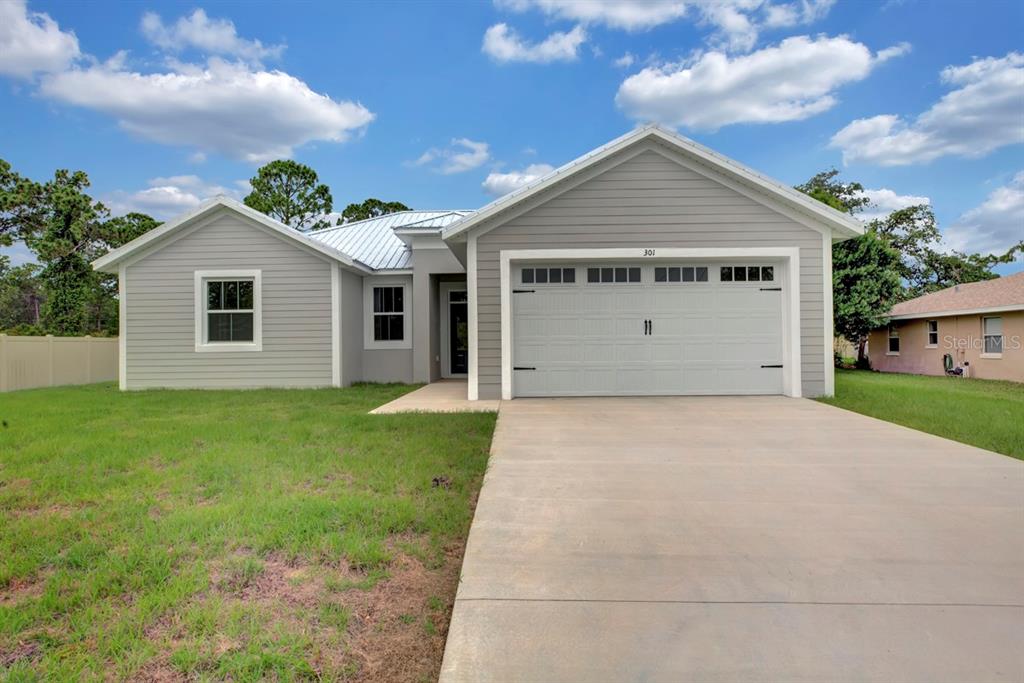 a view of a house with a yard and garage