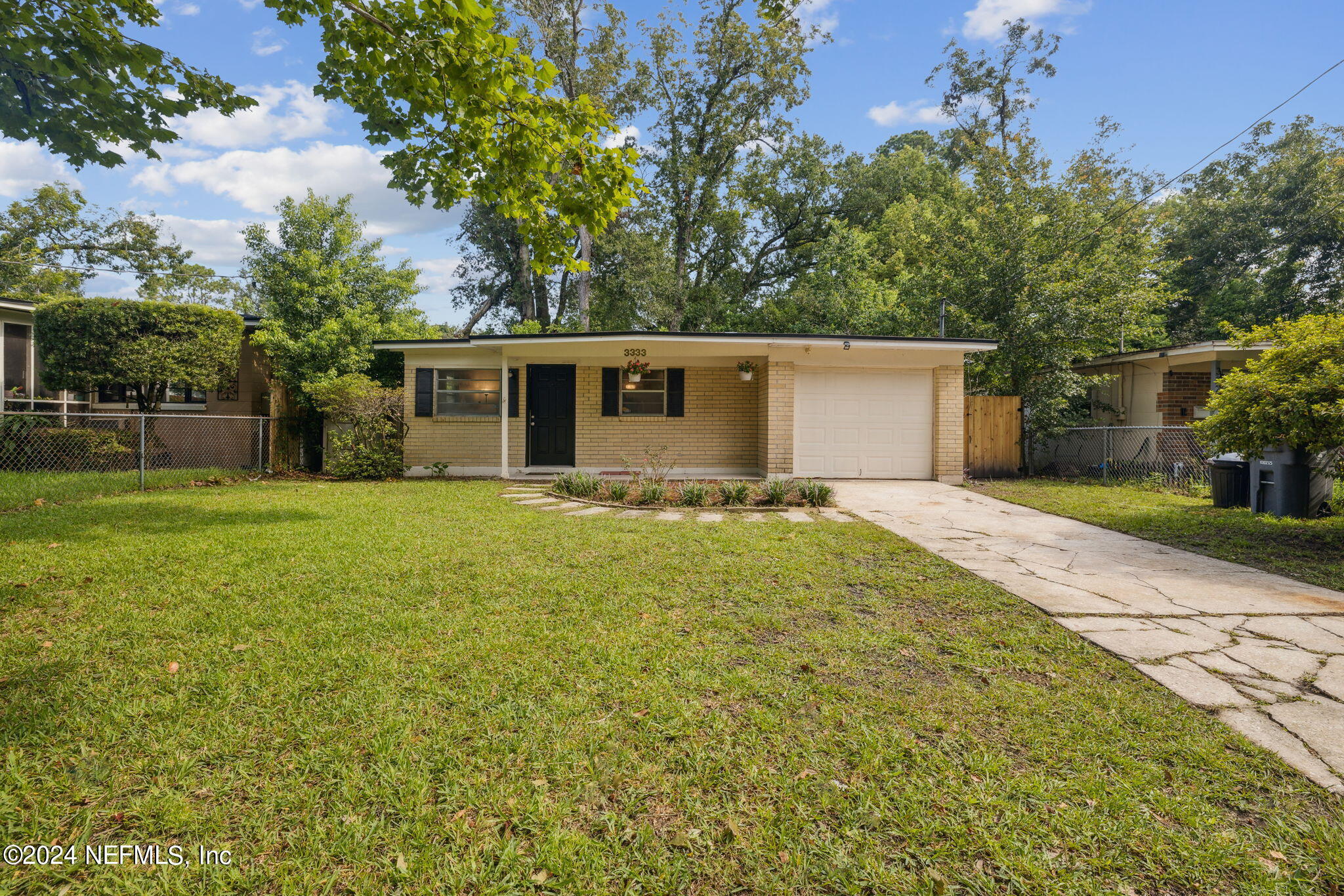 a view of house with backyard and trees