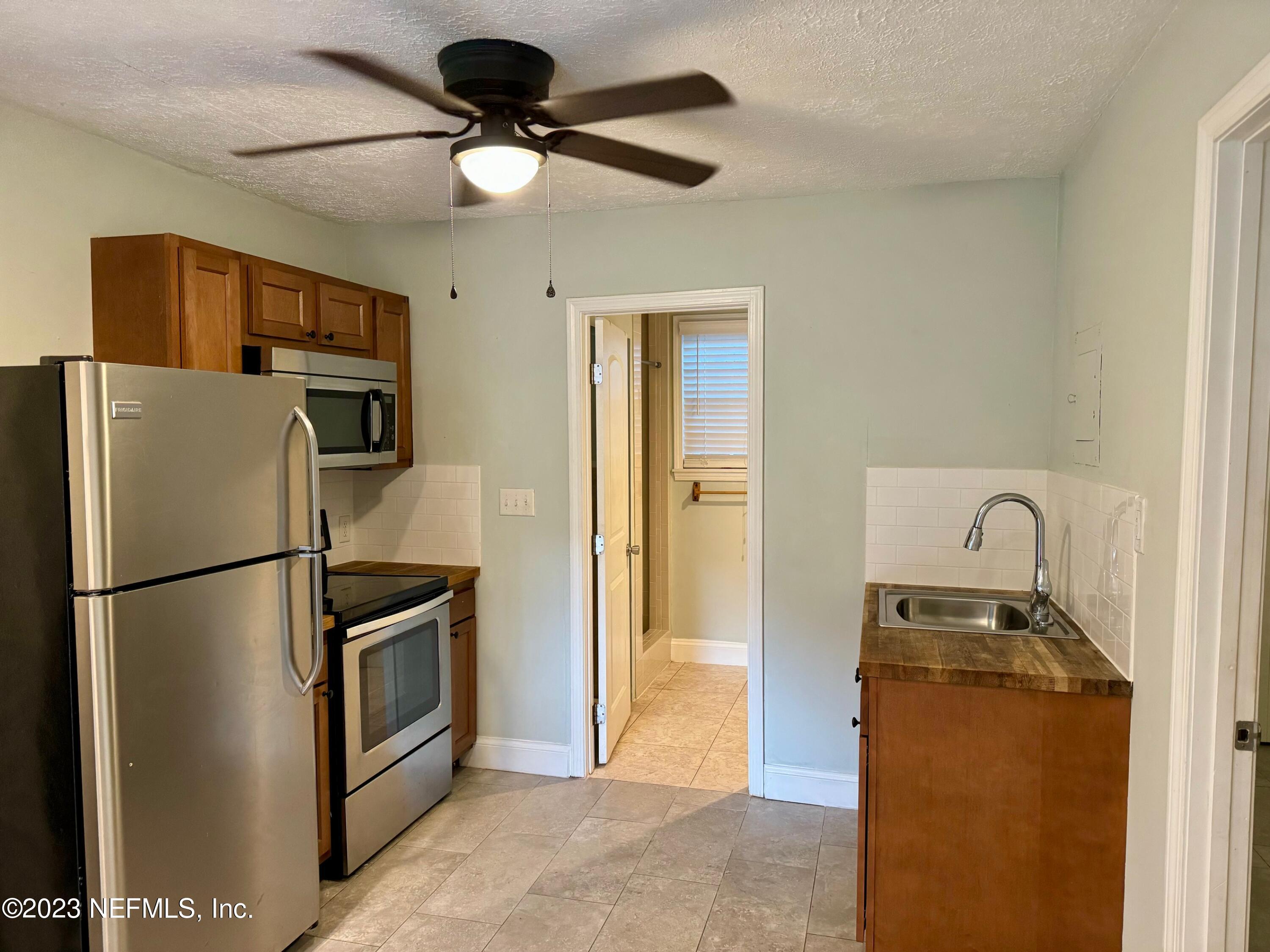 a metallic refrigerator freezer sitting in a kitchen