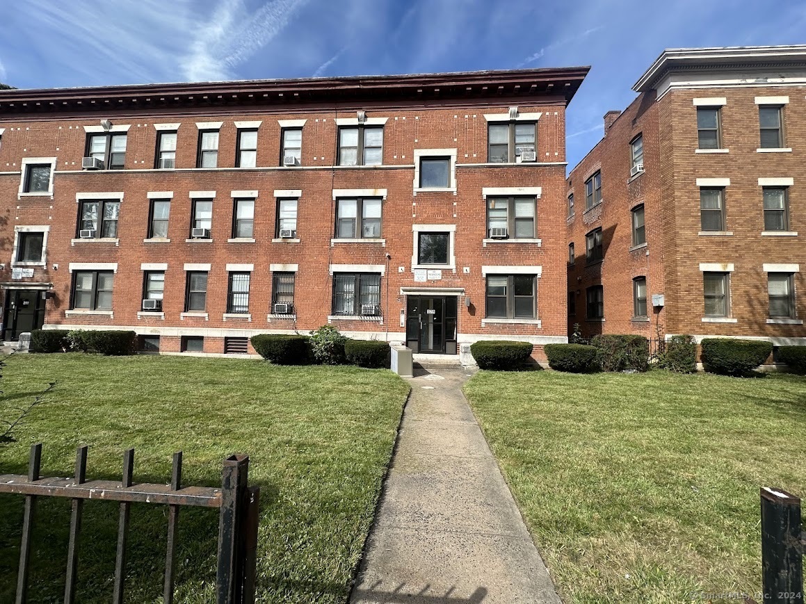 a front view of a building with a garden