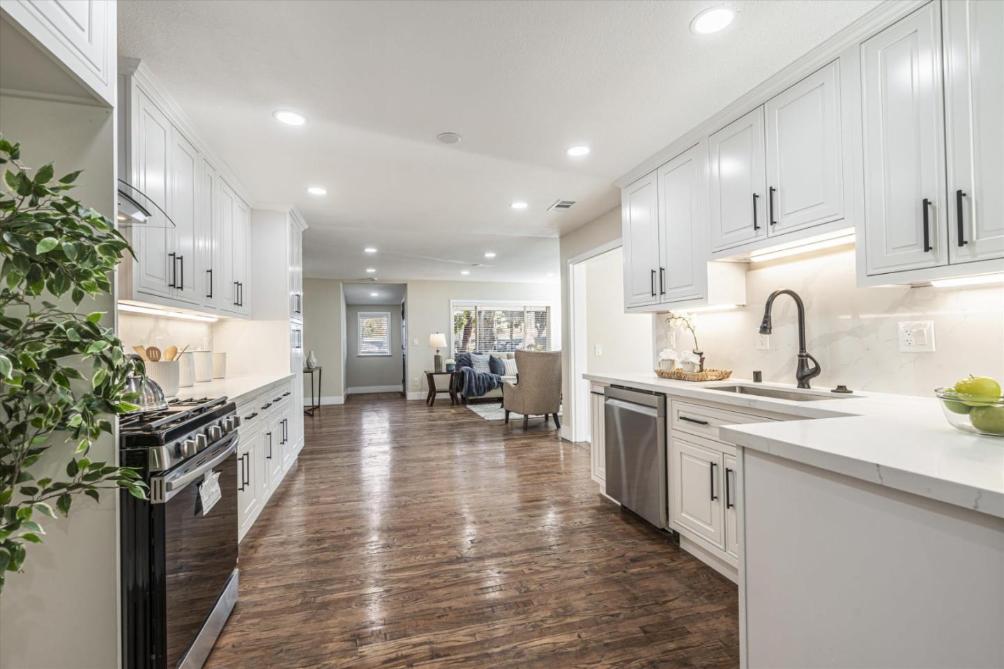 a large kitchen with stainless steel appliances lots of counter space and wooden floor