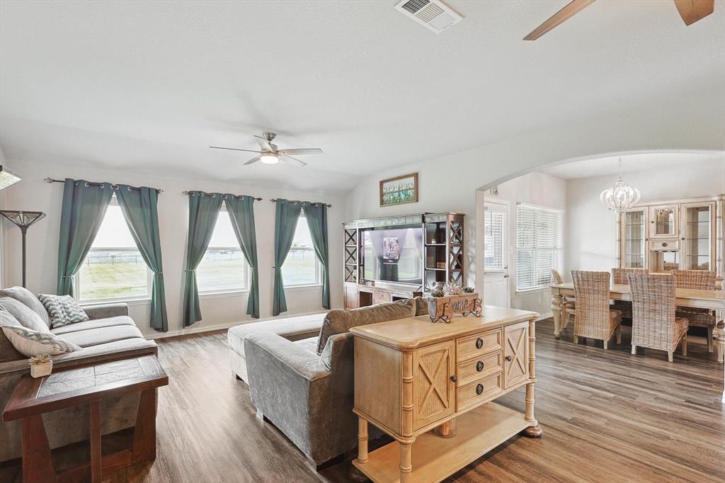 a living room with furniture large window and wooden floor