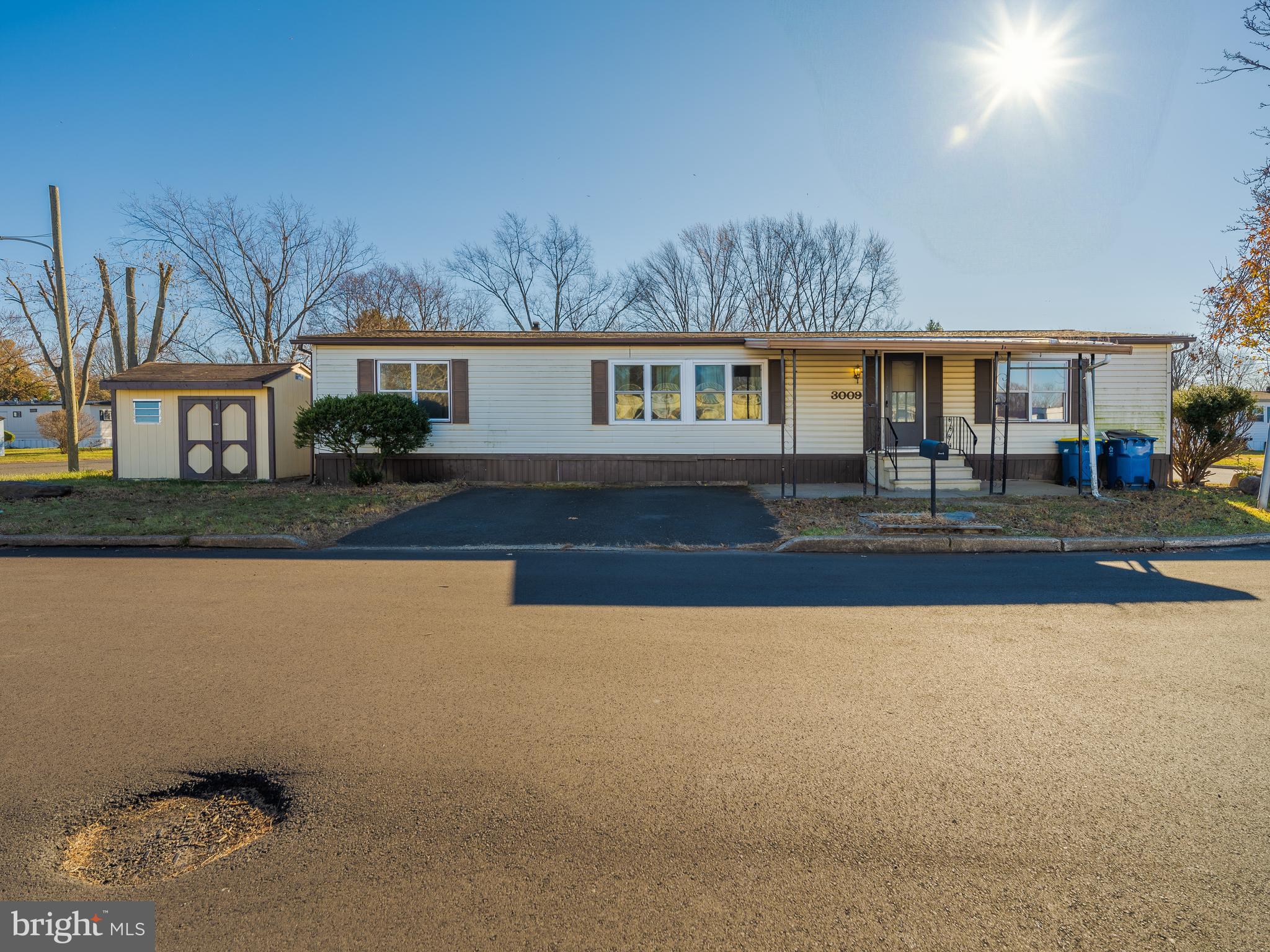 a front view of a house with yard and large tree