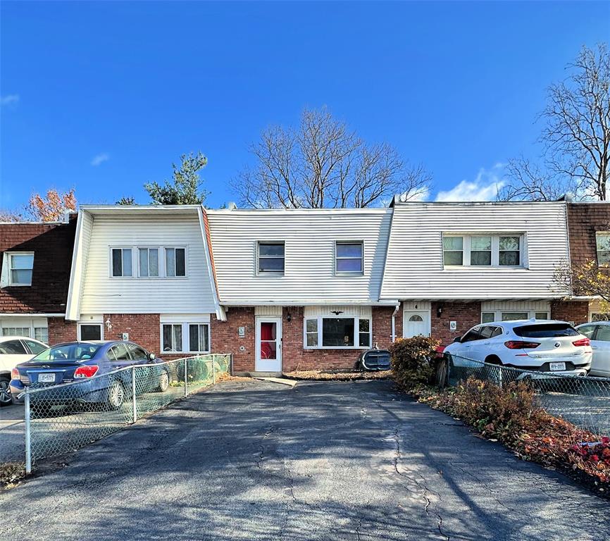 a front view of a house with cars parked