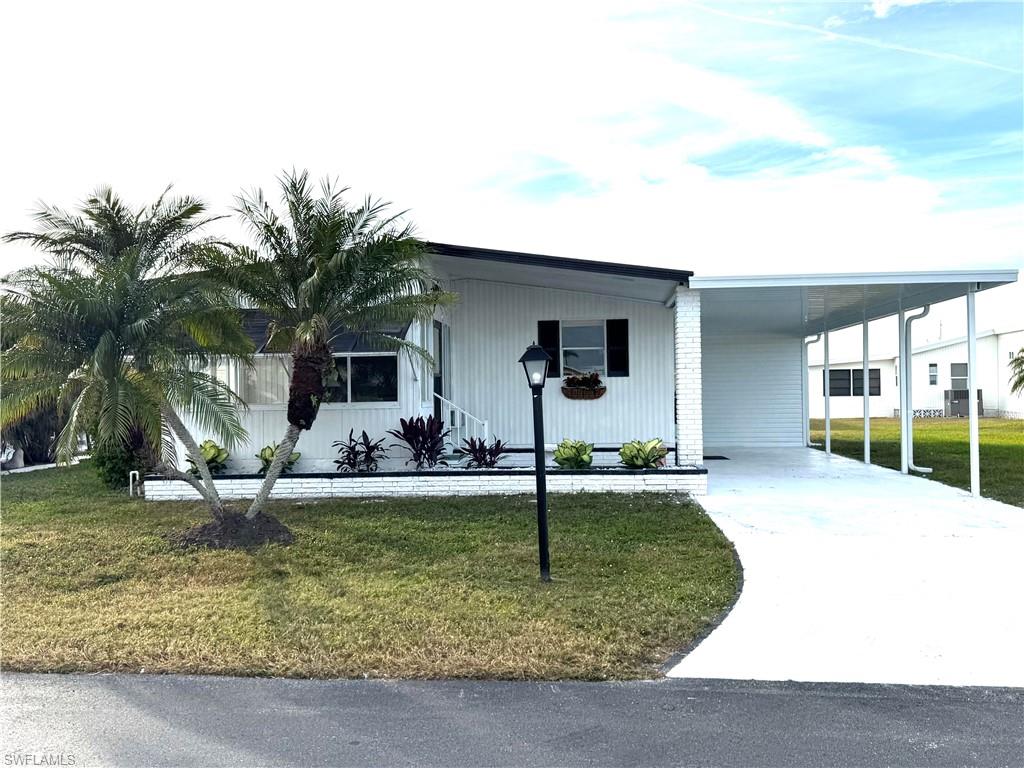 View of front of home featuring a front yard and a carport