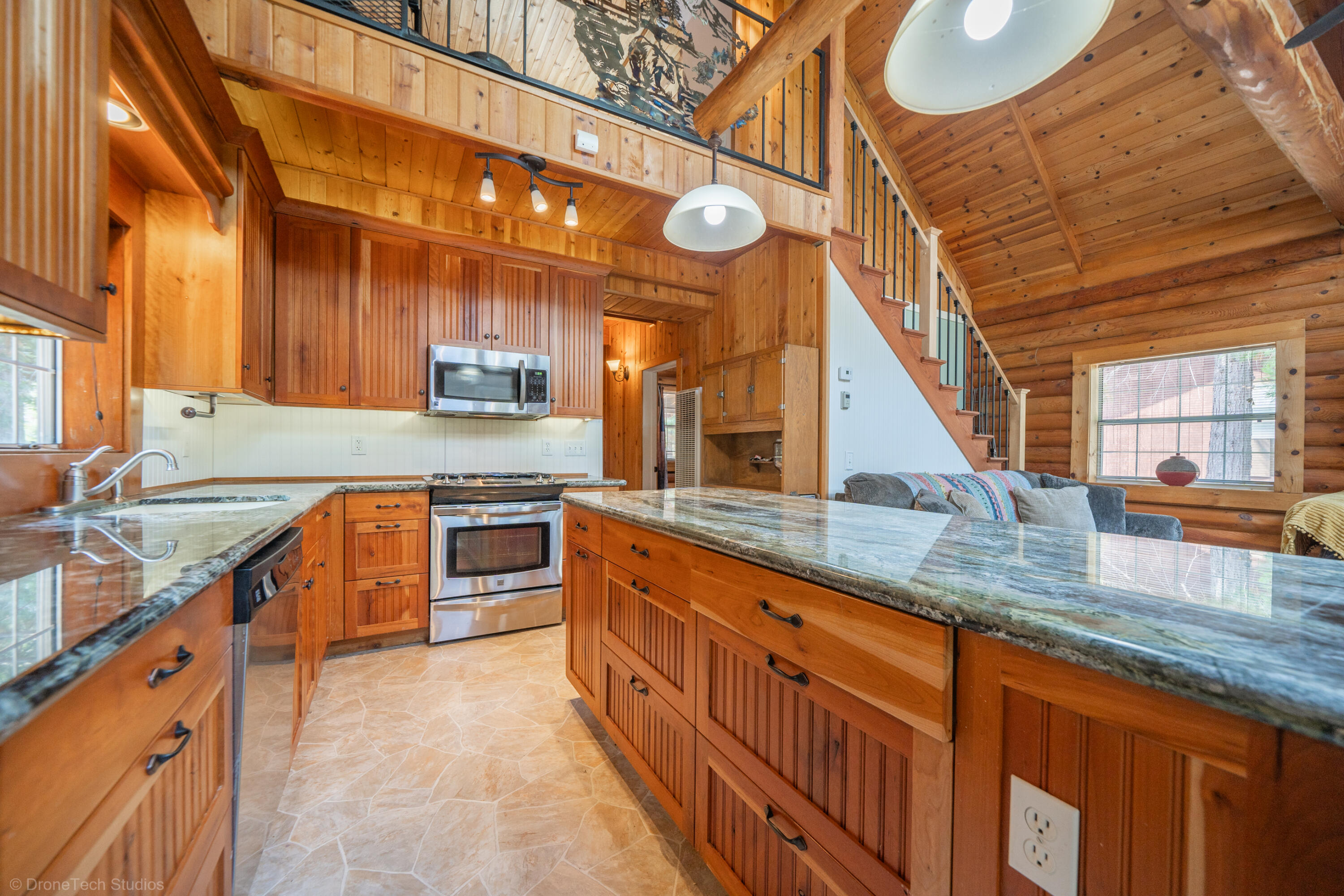 a kitchen with stainless steel appliances granite countertop a sink and a stove