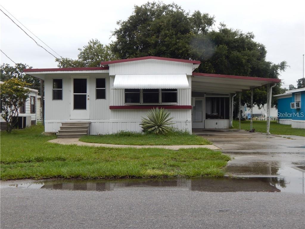 a front view of a house with a garden and trees