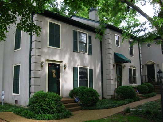 a front view of a house with plants and garden