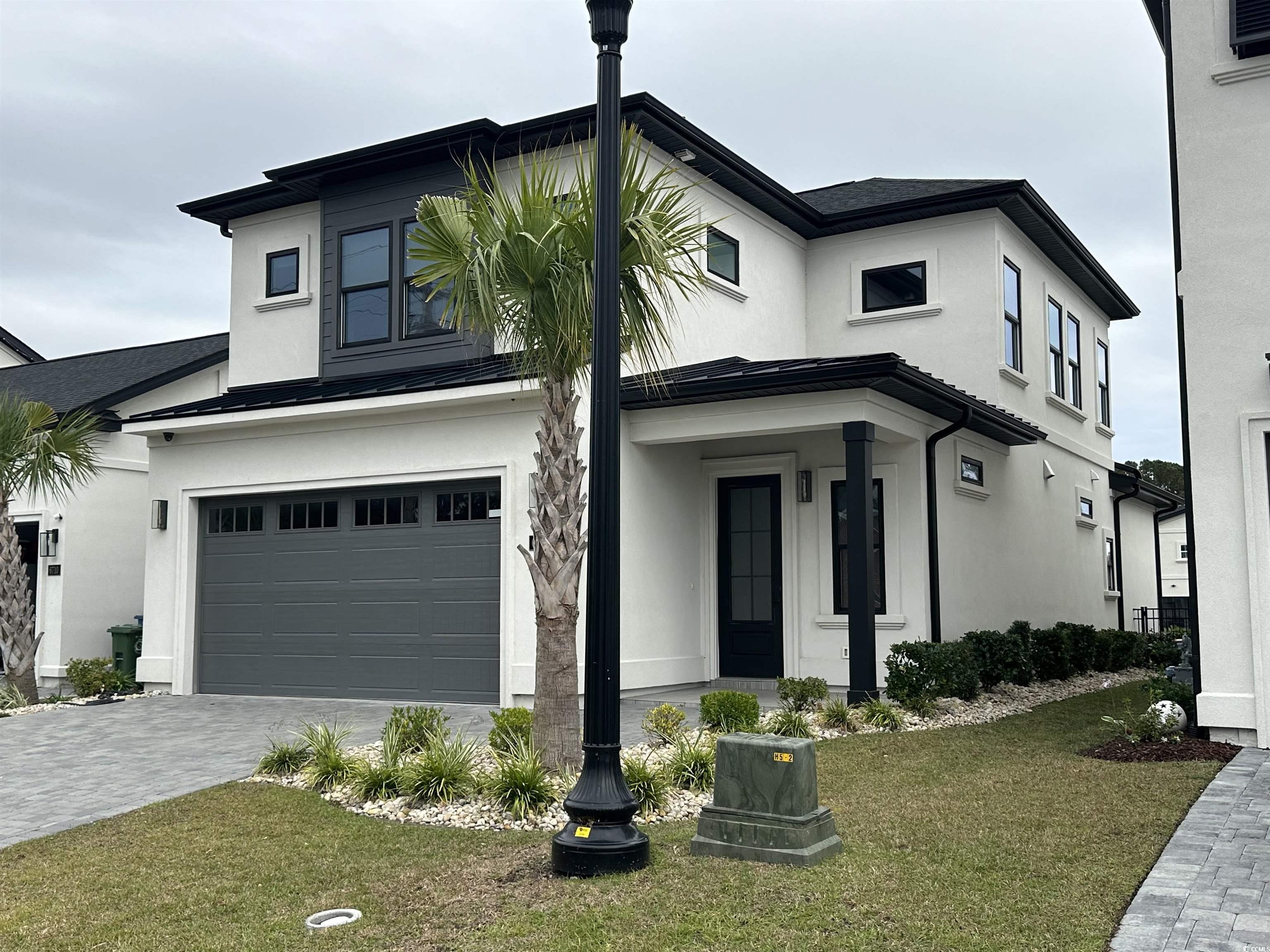 View of front facade with a front lawn and a garag