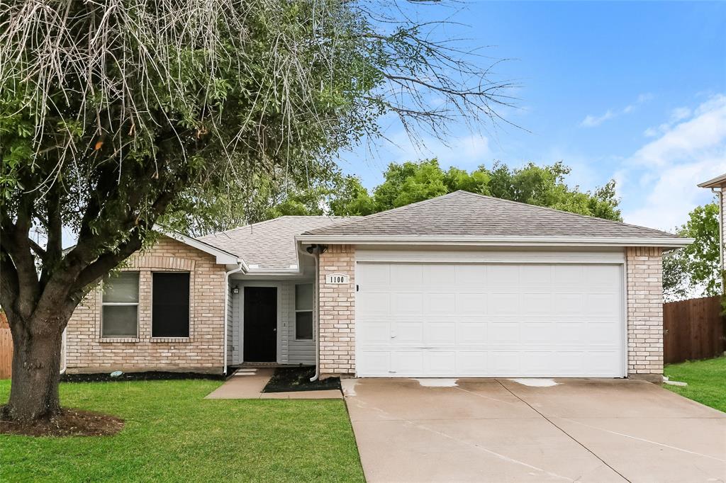 a front view of a house with a yard and a garage