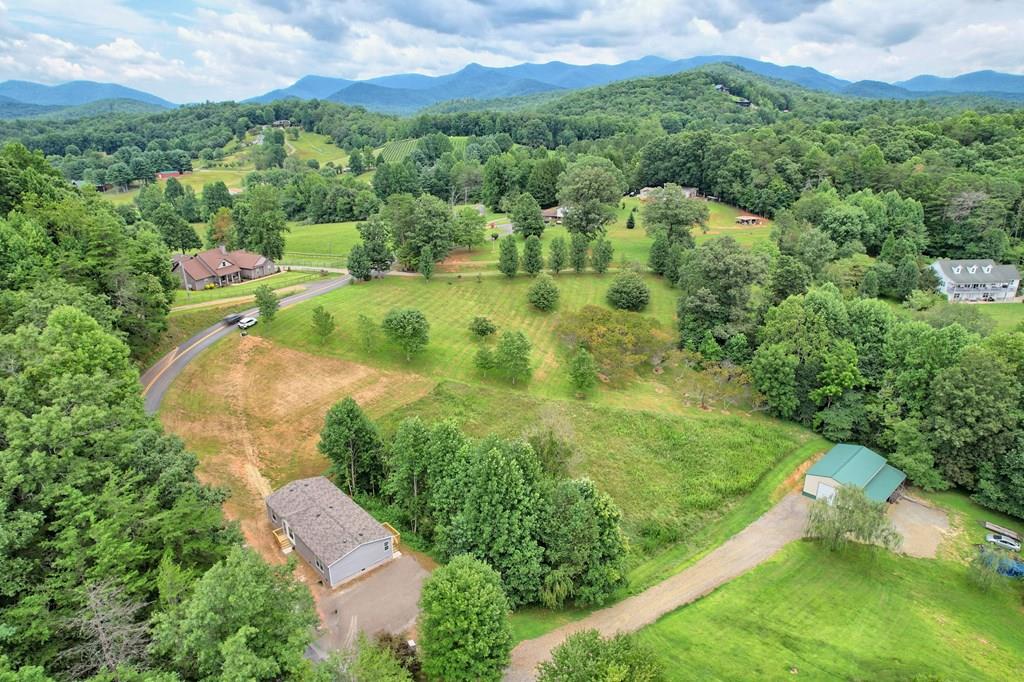 an aerial view of residential houses with outdoor space and trees all around