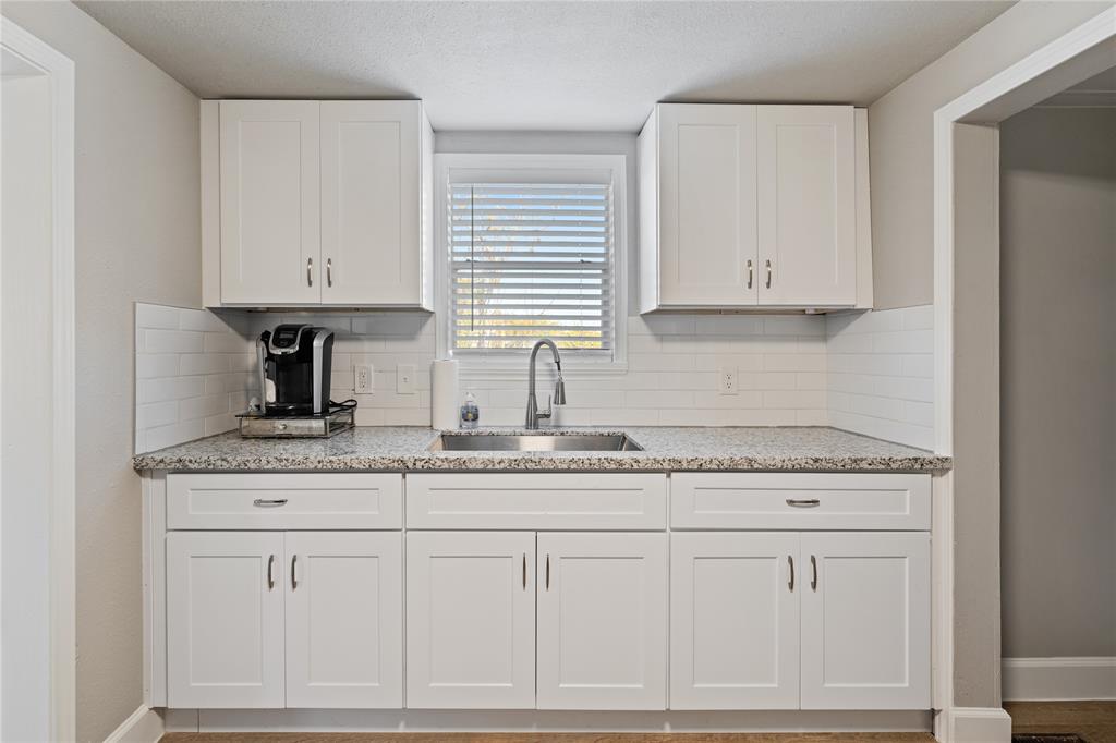 a kitchen with granite countertop white cabinets and white appliances