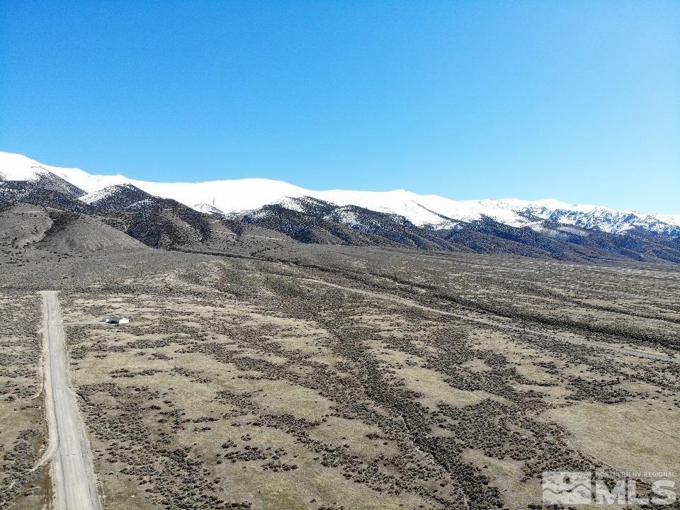 a view of a dry yard with mountains in the background