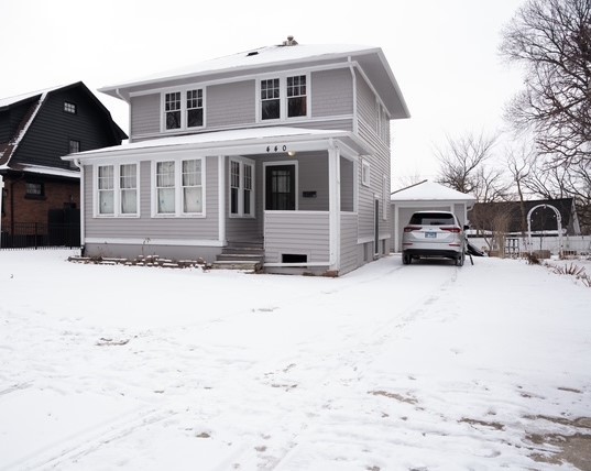 a front view of a house with a yard covered in snow