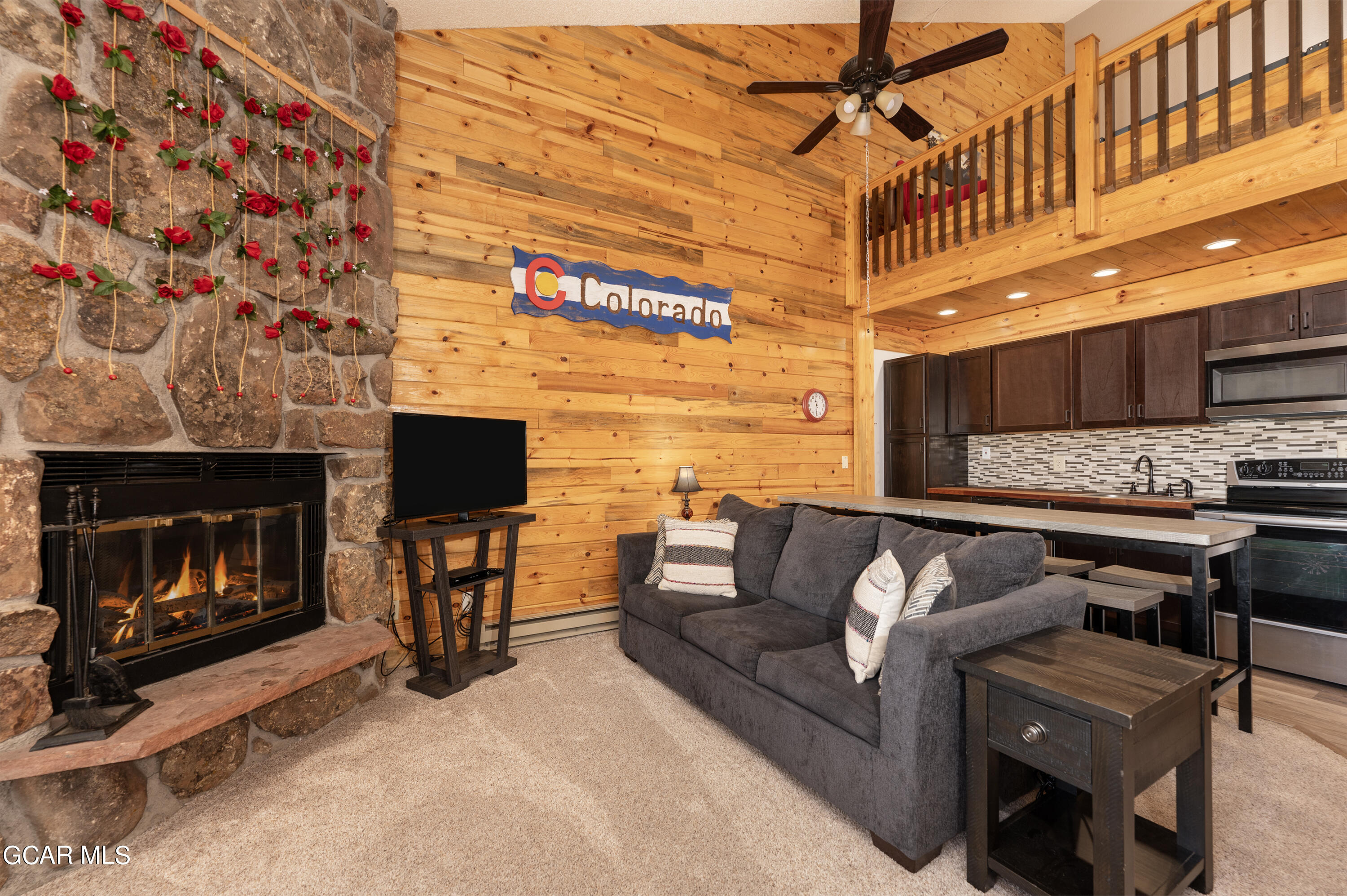 a living room with furniture a flat screen tv and a fireplace