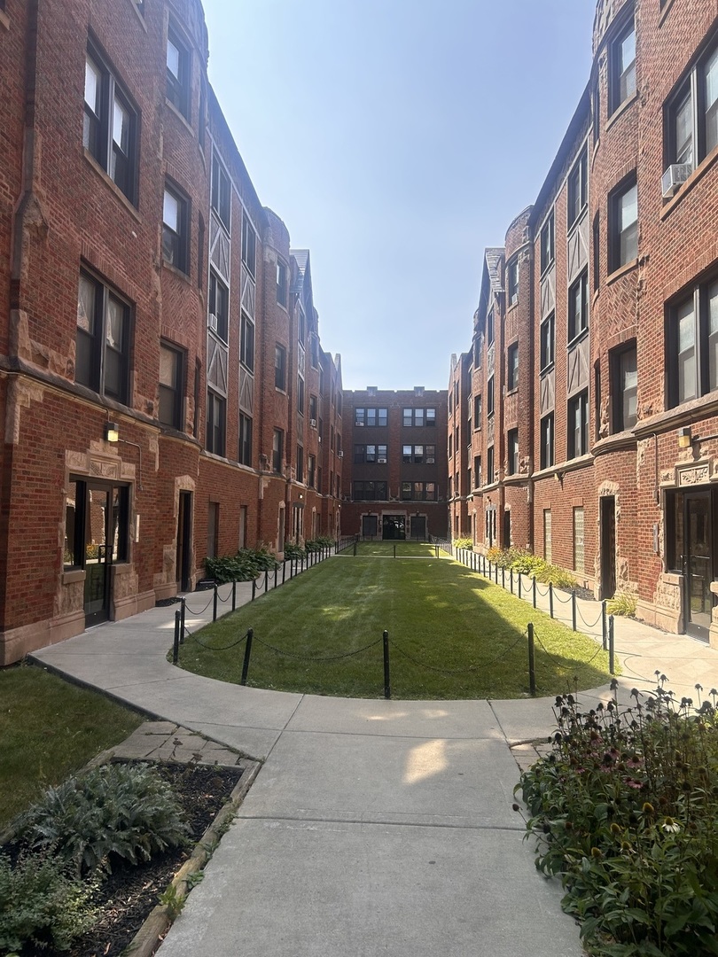 a view of a building with a yard and many windows