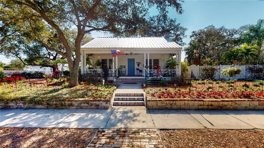 a view of a white house with lots of potted plants