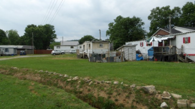 a view of a house with a big yard and sitting area