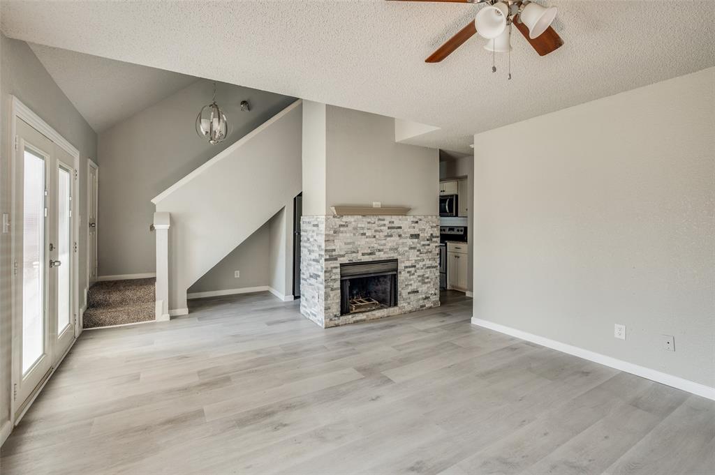 wooden floor fireplace and windows in an empty room