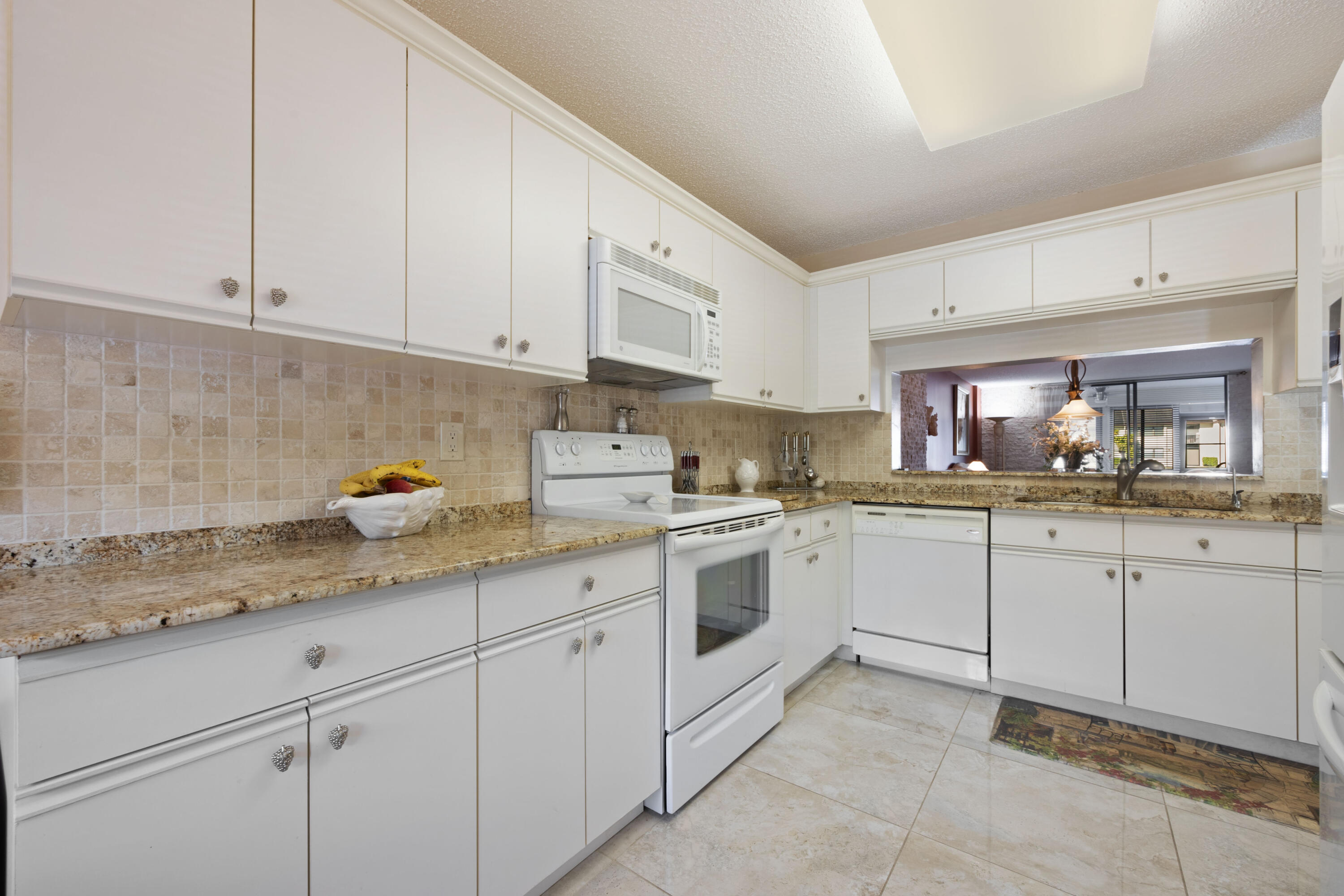 a kitchen with granite countertop white cabinets stainless steel appliances and sink