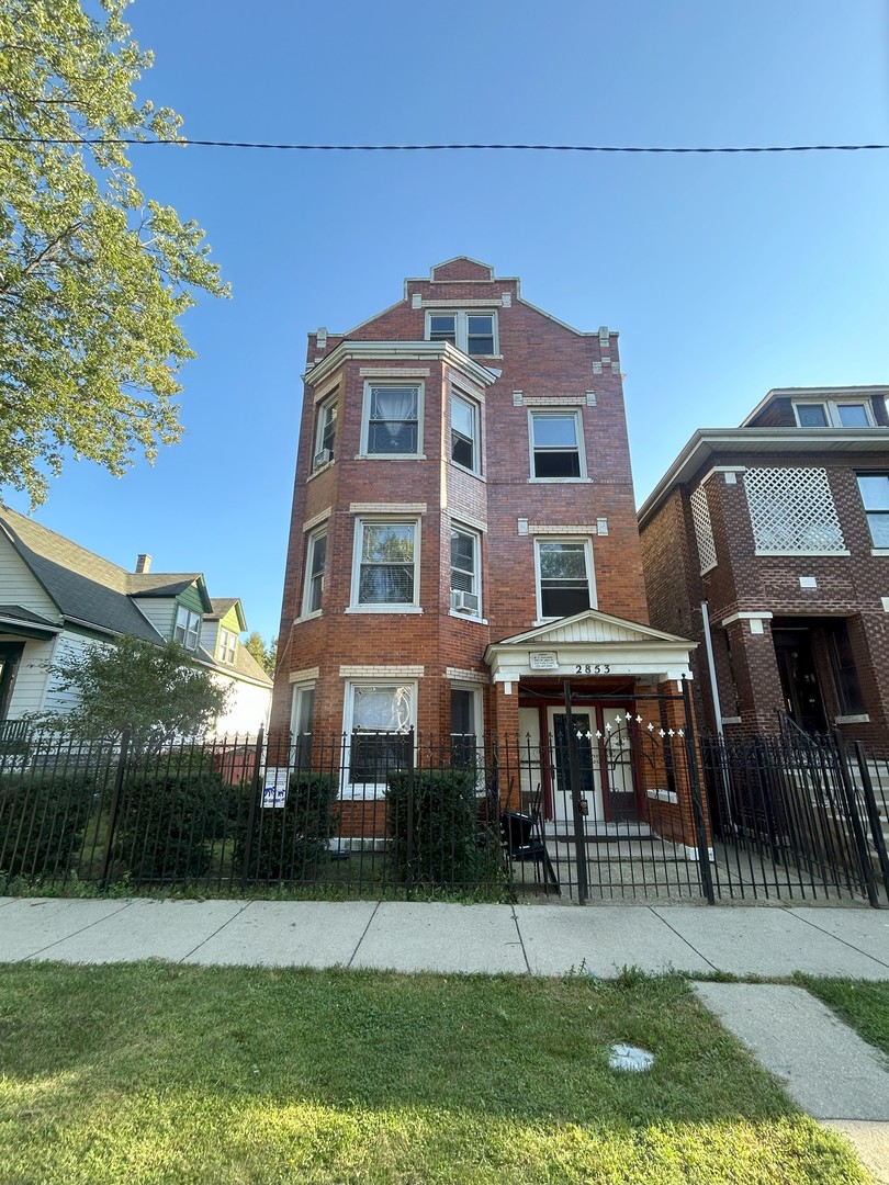 a front view of a residential apartment building with a yard