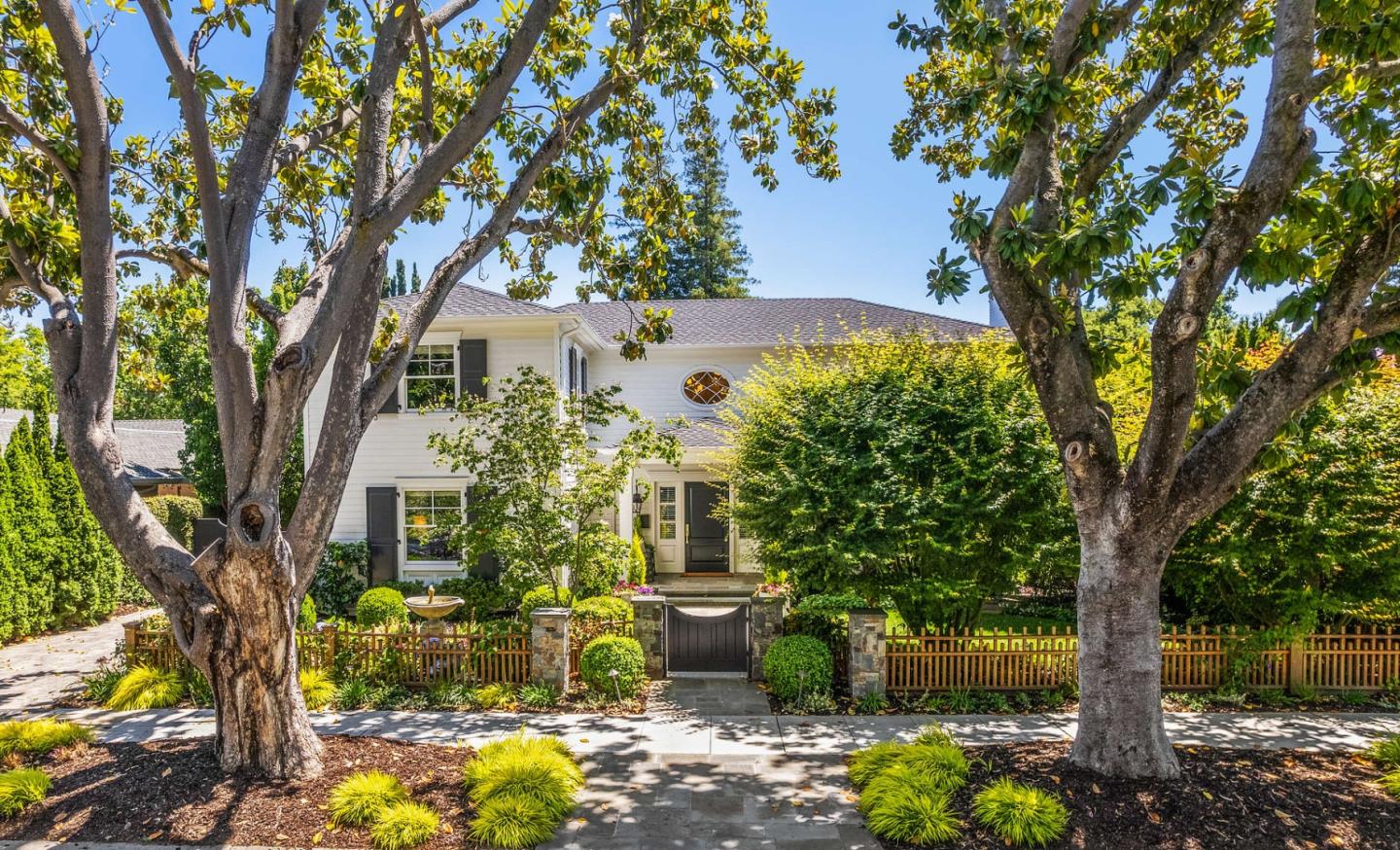 a front view of a house with yard and trees