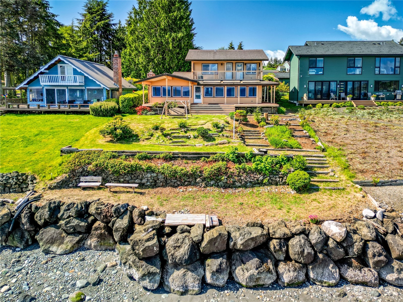 a front view of a residential houses with yard and green space