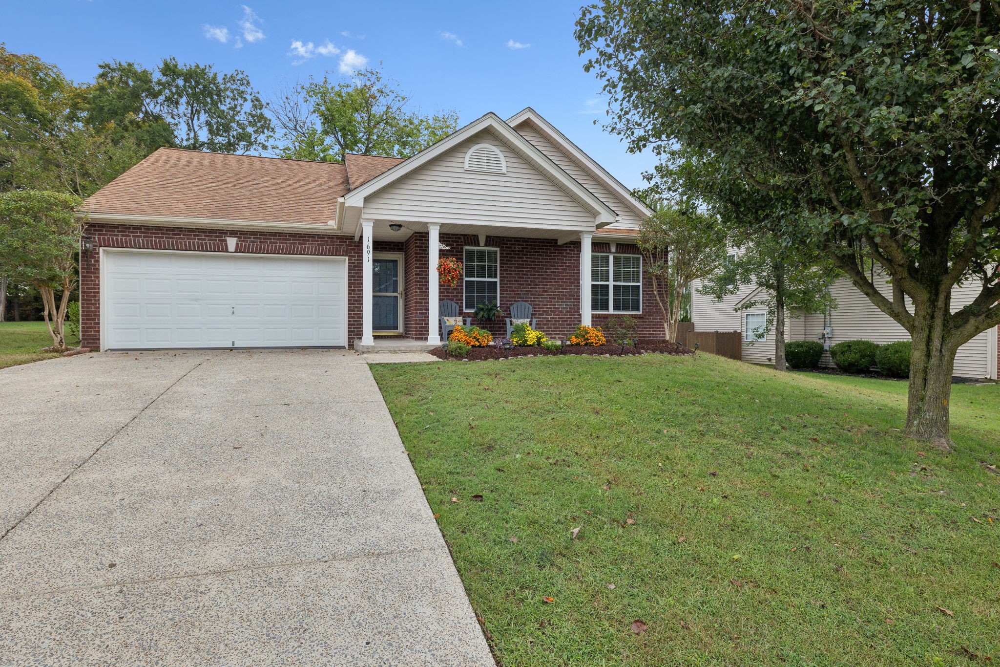 a front view of a house with a yard and trees