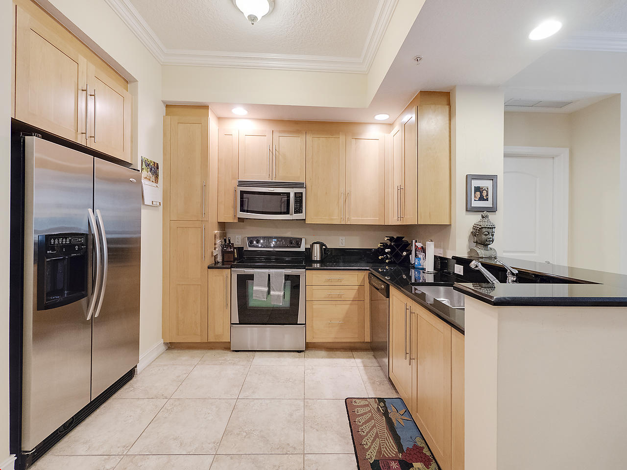 a kitchen with granite countertop a refrigerator and a sink