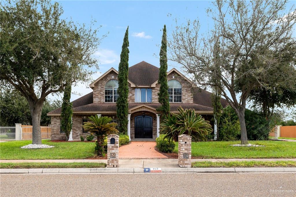 a front view of a house with a garden and plants