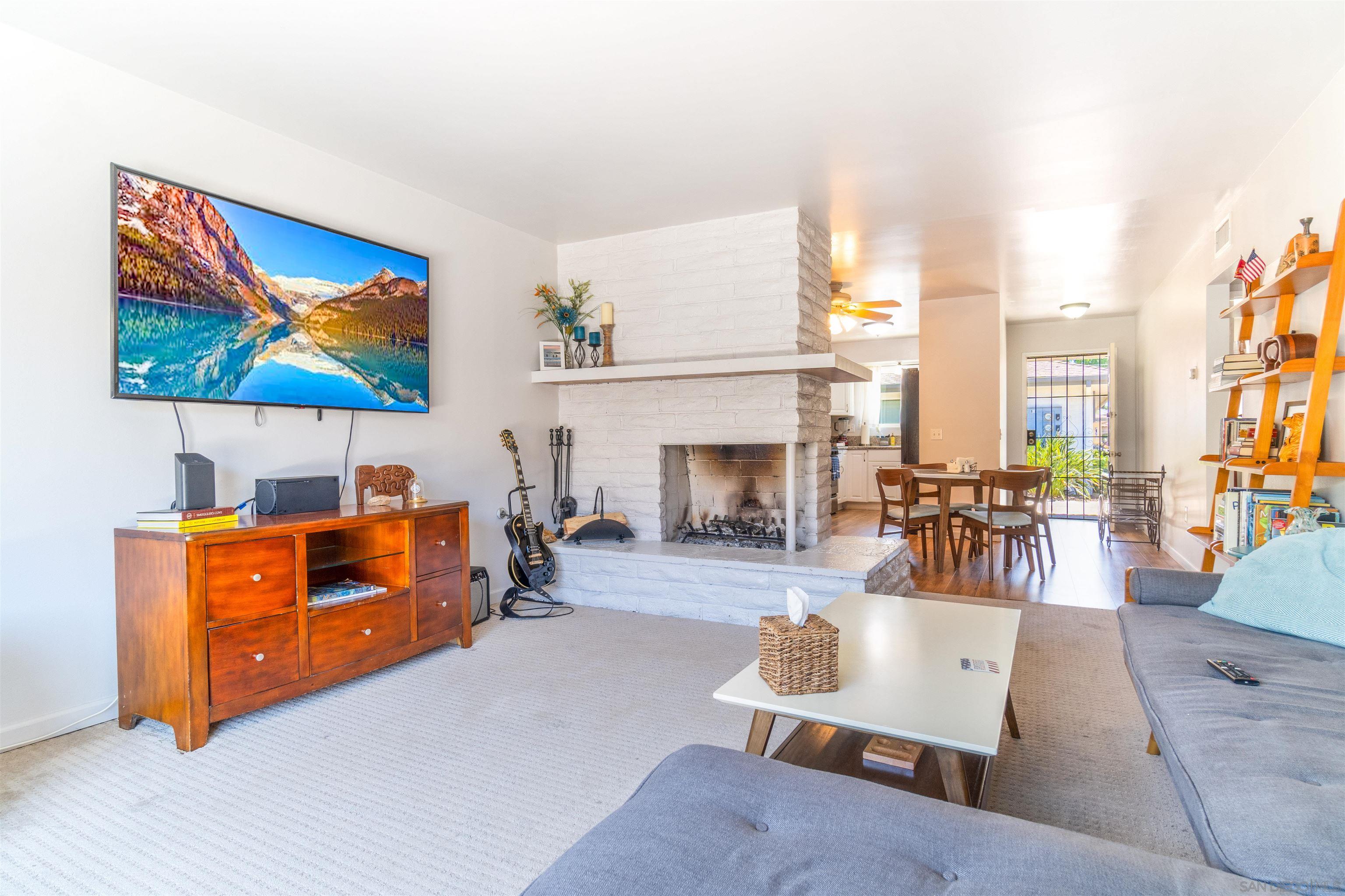 a living room with furniture a fireplace and a flat screen tv