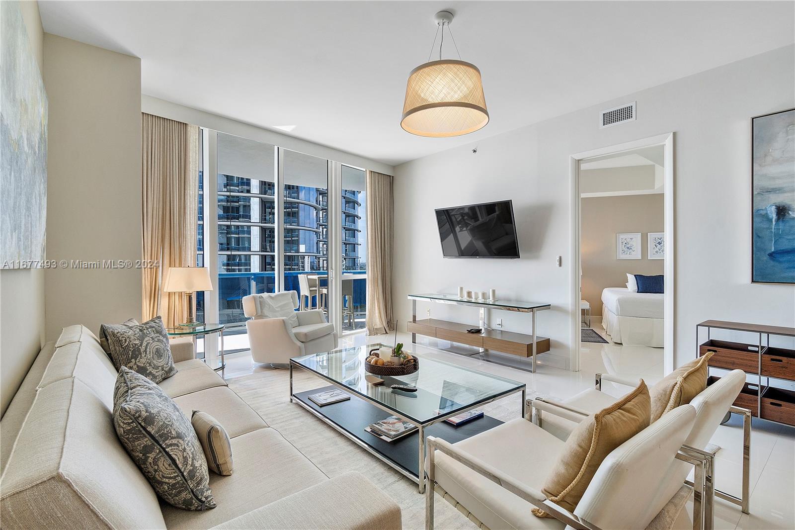 a living room with furniture a flat screen tv and a large window