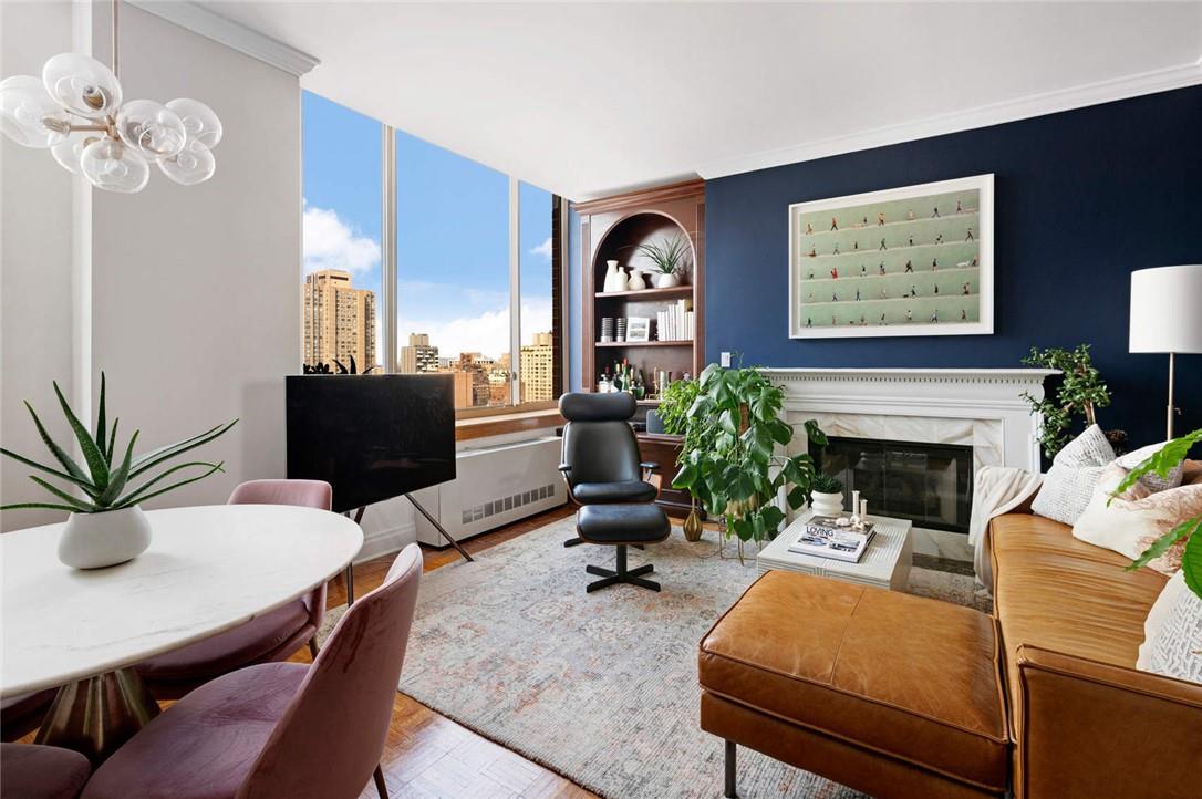 a living room with furniture a fireplace and a potted plant