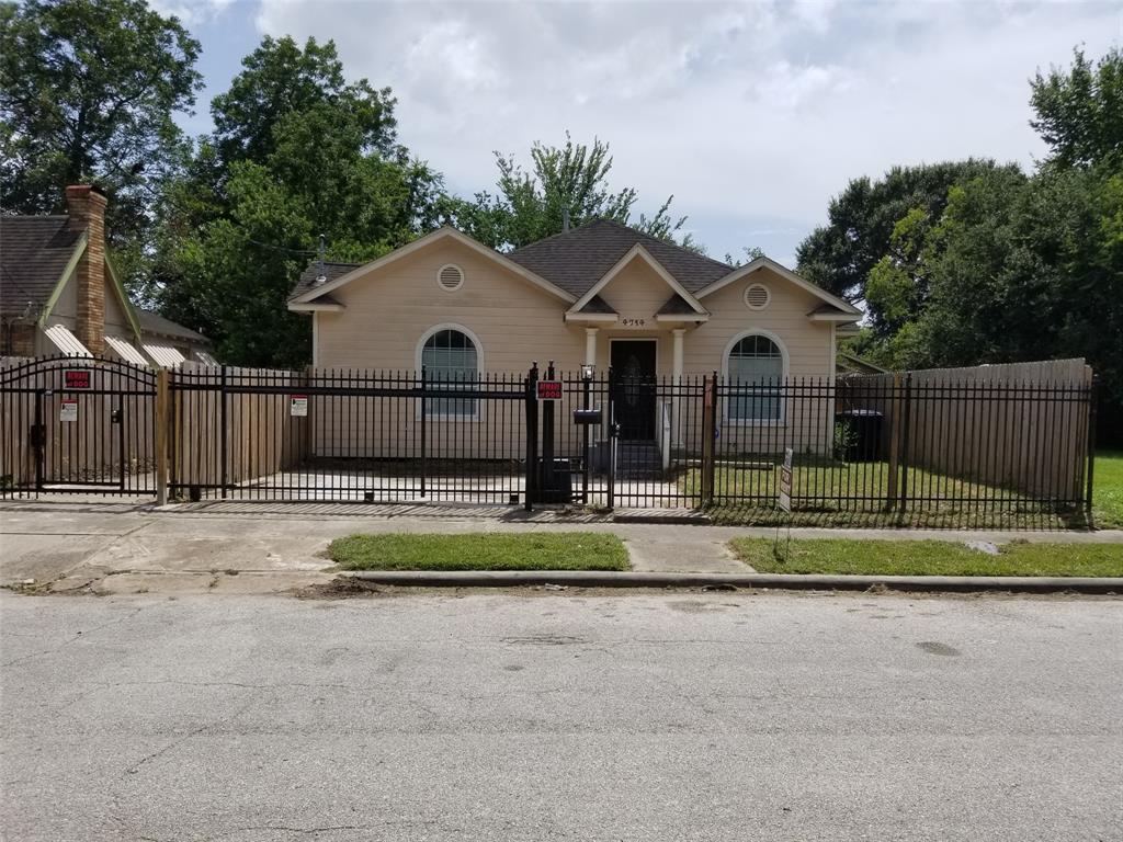 a view of a house with a yard and large tree