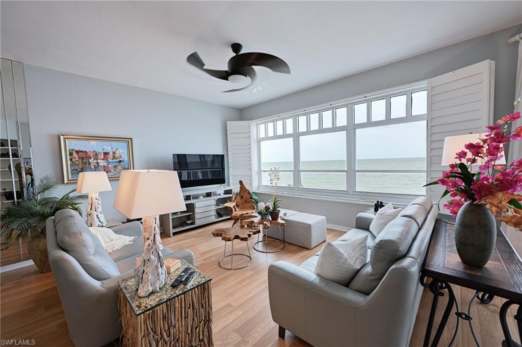 a living room with furniture a flat screen tv and a large window