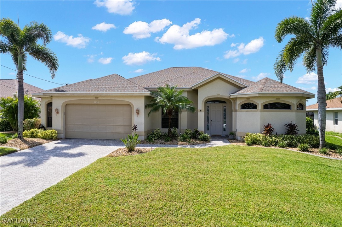 a front view of a house with yard and parking