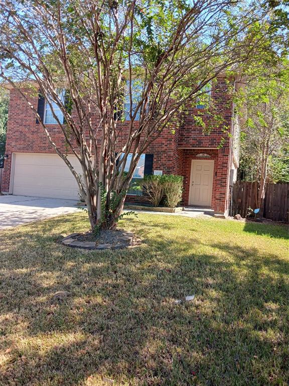 a view of a house with backyard and tree