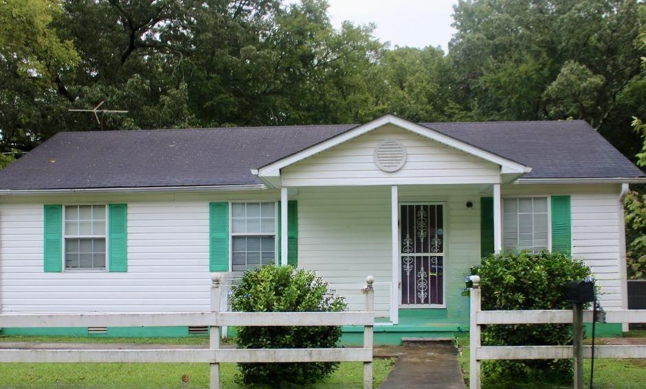 a front view of a house with a yard and potted plants