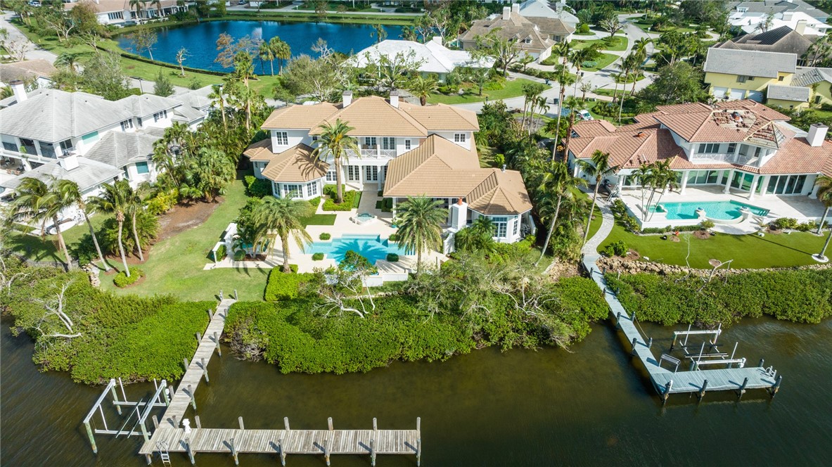 an aerial view of residential houses with outdoor space and lake view