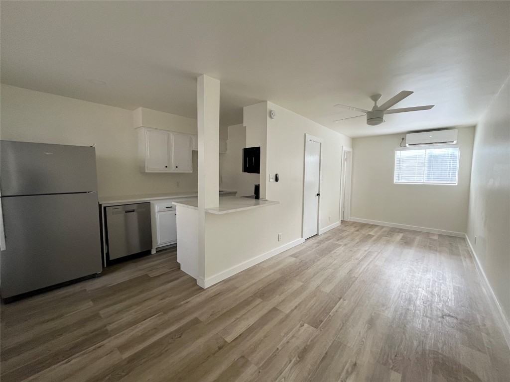 a view of a kitchen with wooden floor and a window