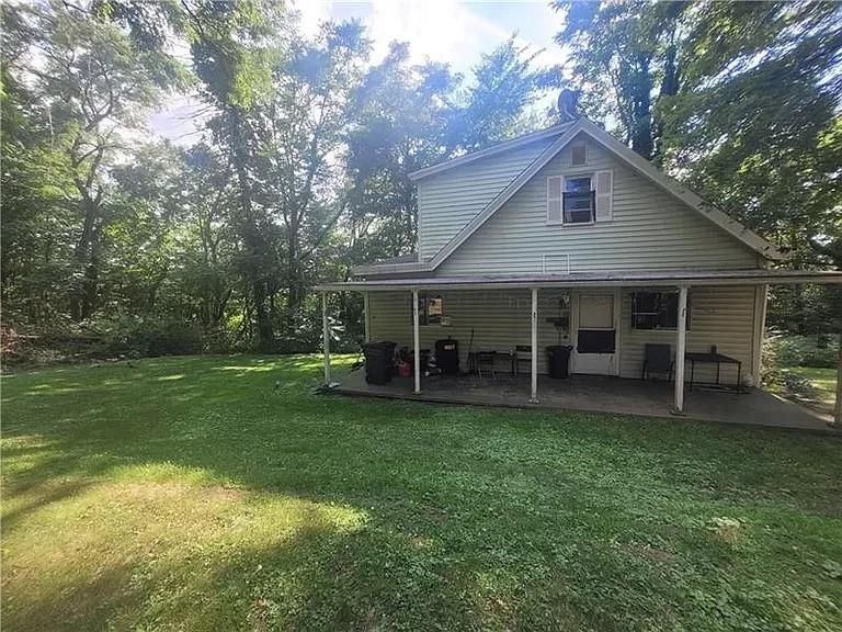 a view of a house with a yard and sitting area