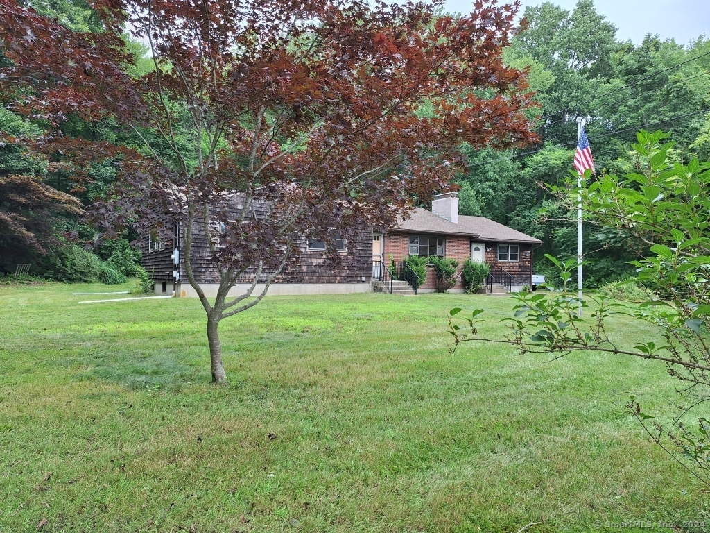 a front view of house with yard and green space