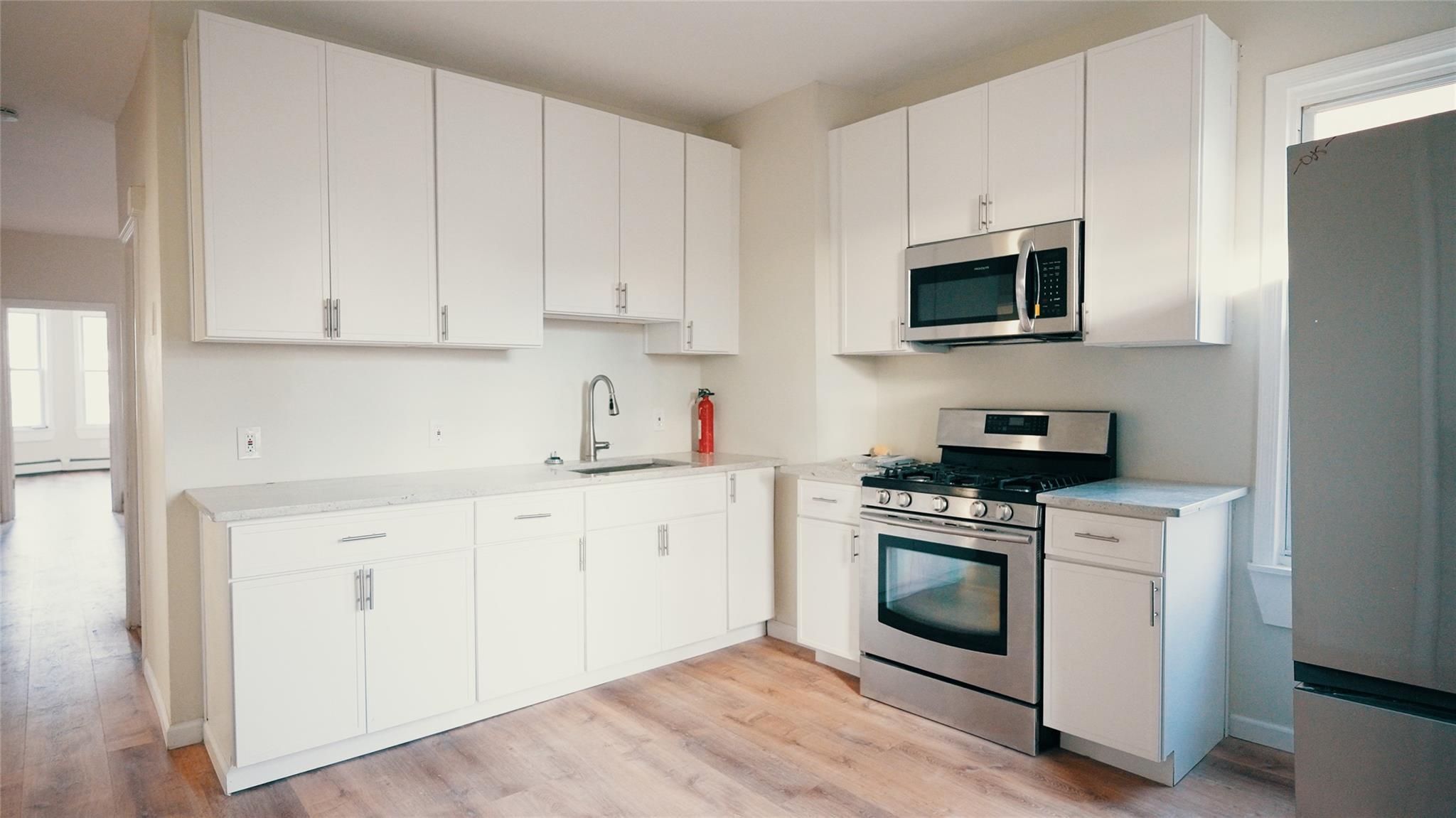 a kitchen with white cabinets and white appliances