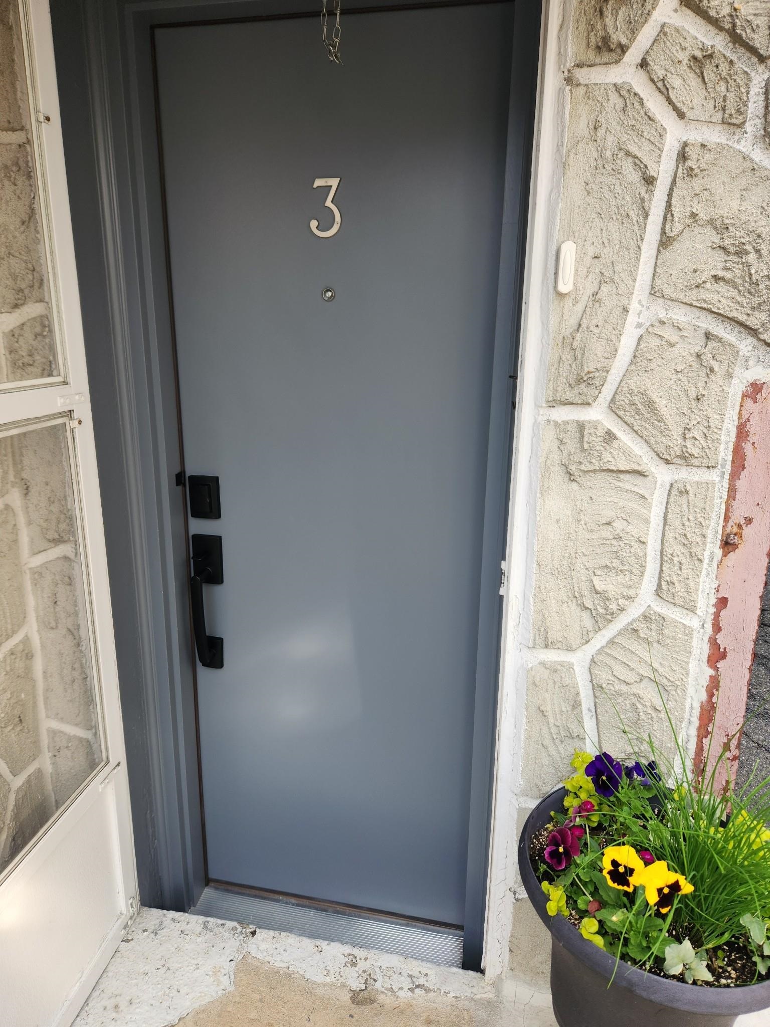 a view of a door and chair in the corridor