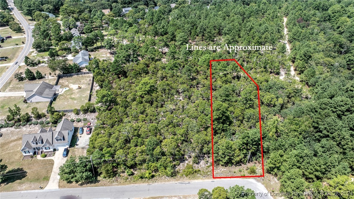 an aerial view of residential house with outdoor space and trees all around