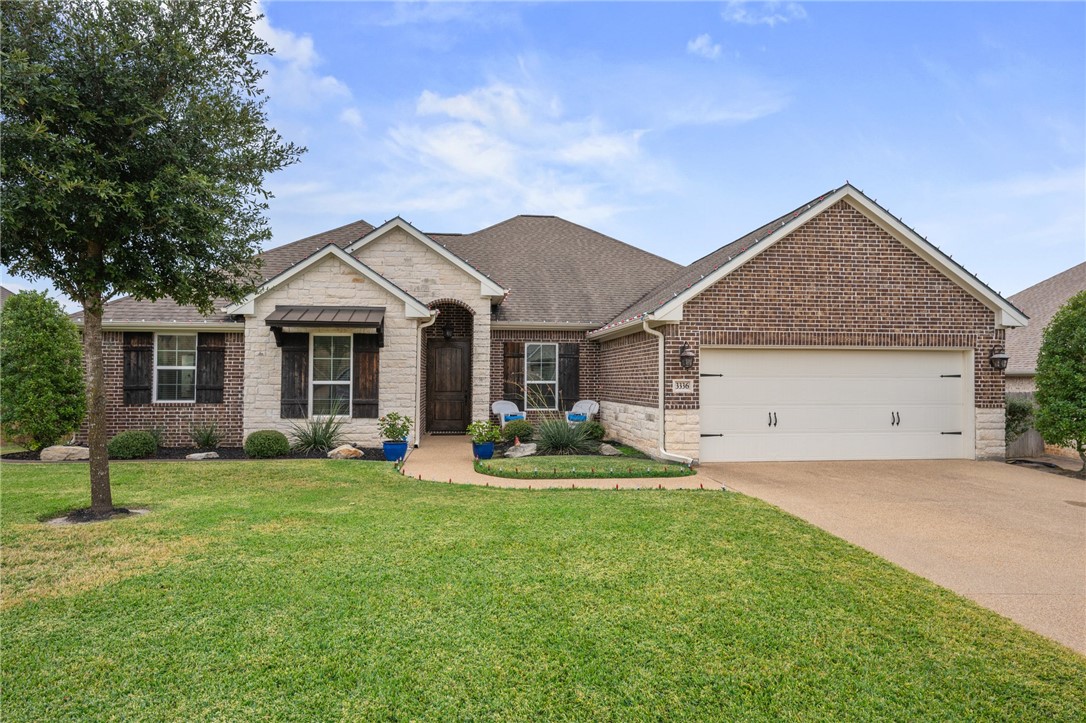 View of front of house with a front yard and a gar